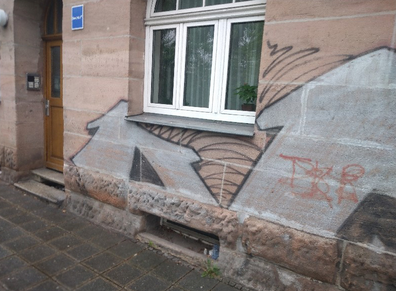 Graffitientferung Graffitischutz Nürnberg vorher Graffiti auf Natursteinfassade vor der Reinigung